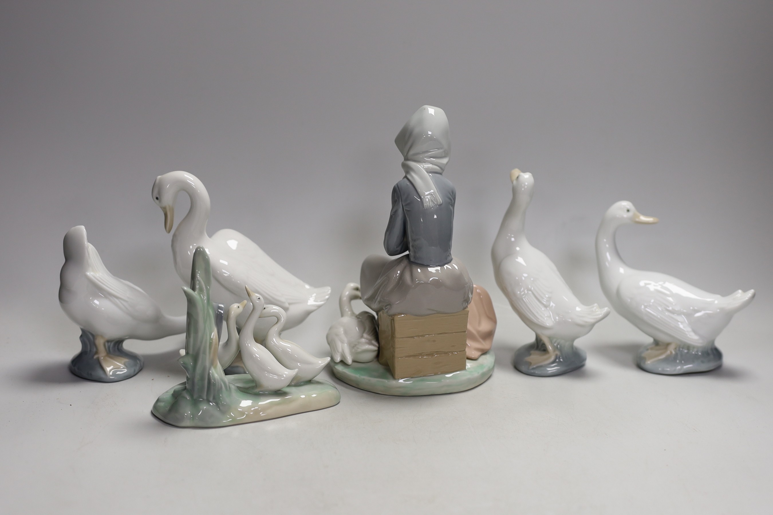 A Lladro seated girl with ducks and five Nao ducks